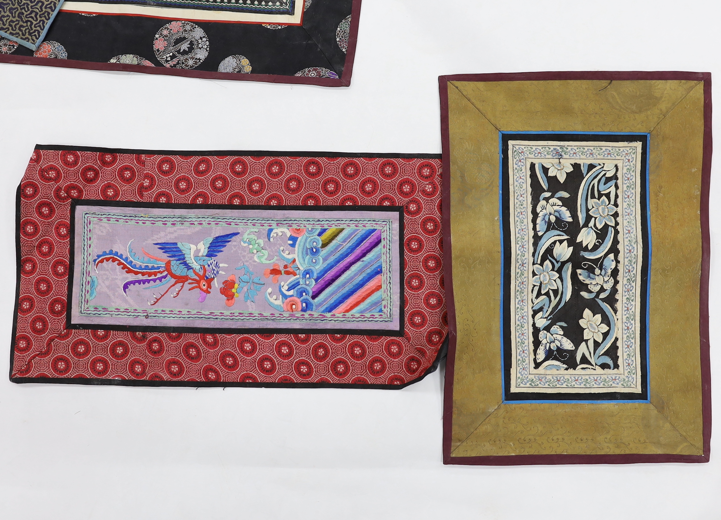 Twelve various Chinese rectangular silk polychrome embroidered mats with damask borders, of varying sizes